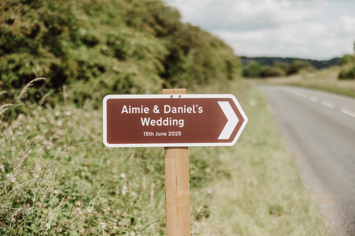 Brown wedding sign photographed pointing towards Staffordshire farm wedding