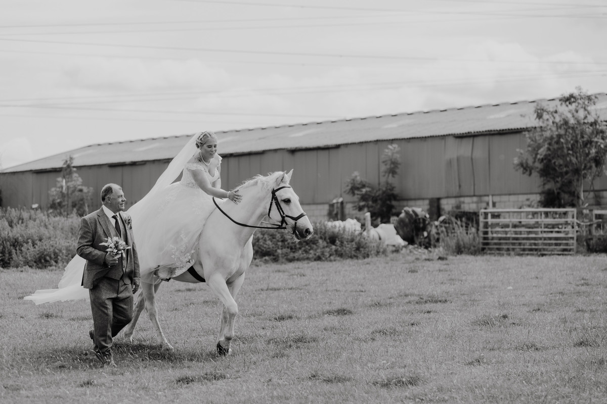Bride walks on horseback to her wedding ceremony with Dad on foot