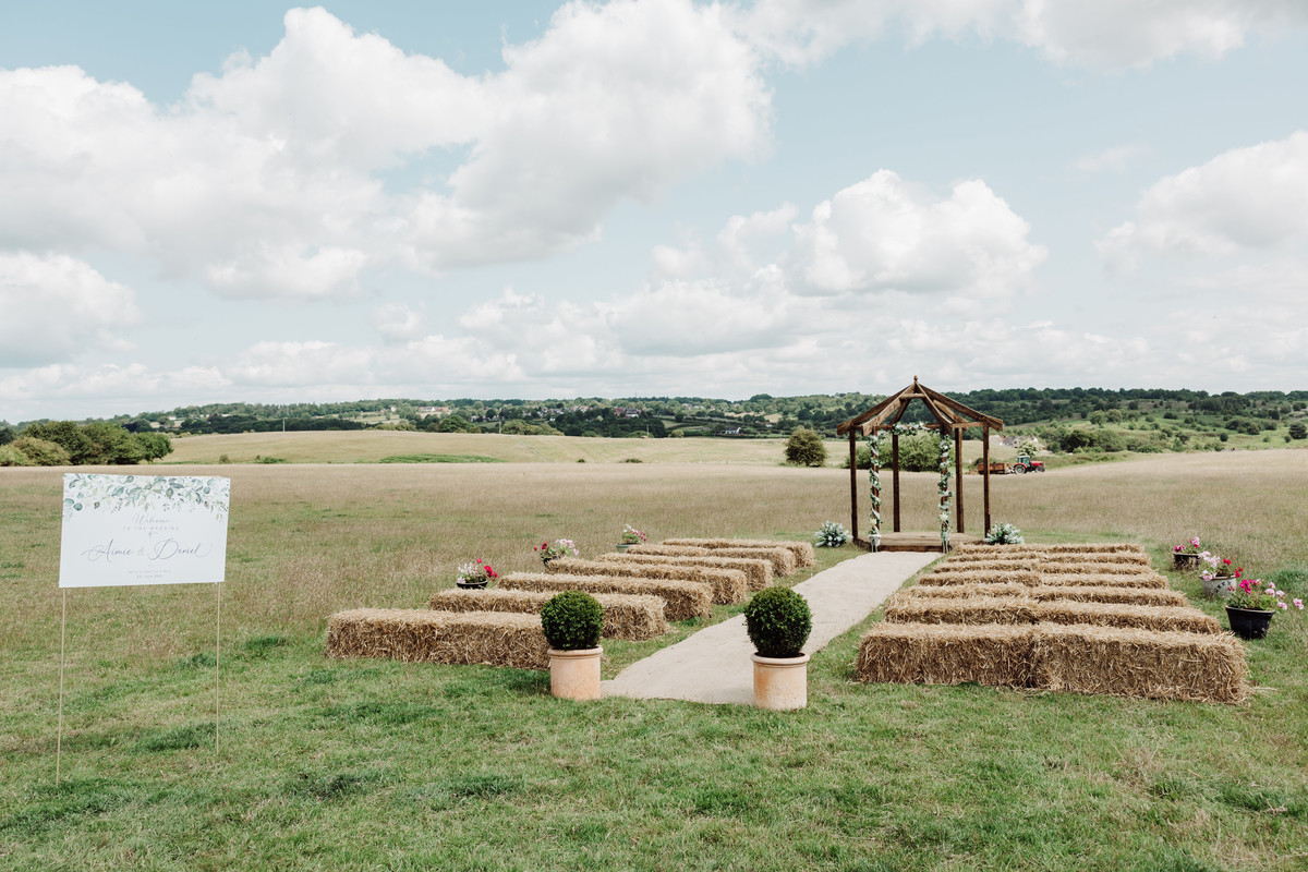 Outdoor ceremony location on a farm photographed in Staffordshire with hay bales for seats