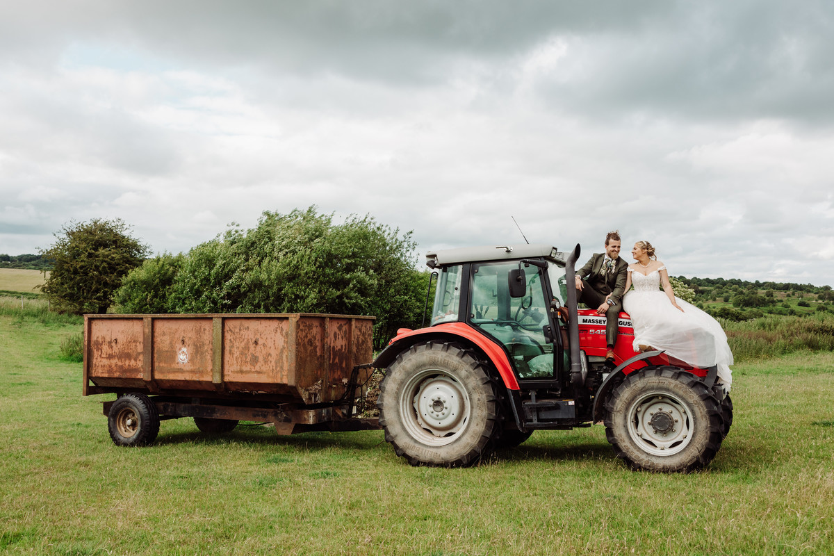 Bride and Groom sit on bonnet of Massey Ferguson on their wedding day in Staffordshire