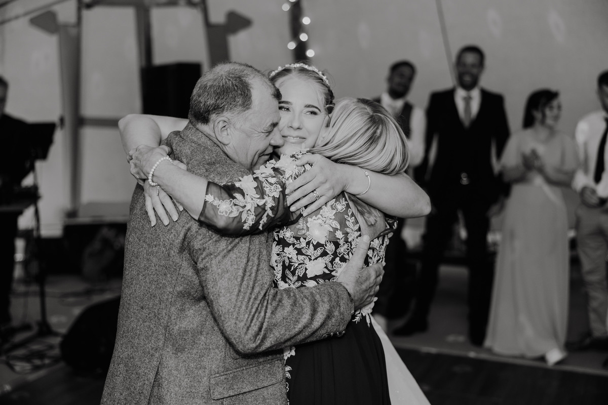 Bride embraces Mum and Dad on the dance floor at her Tipi wedding