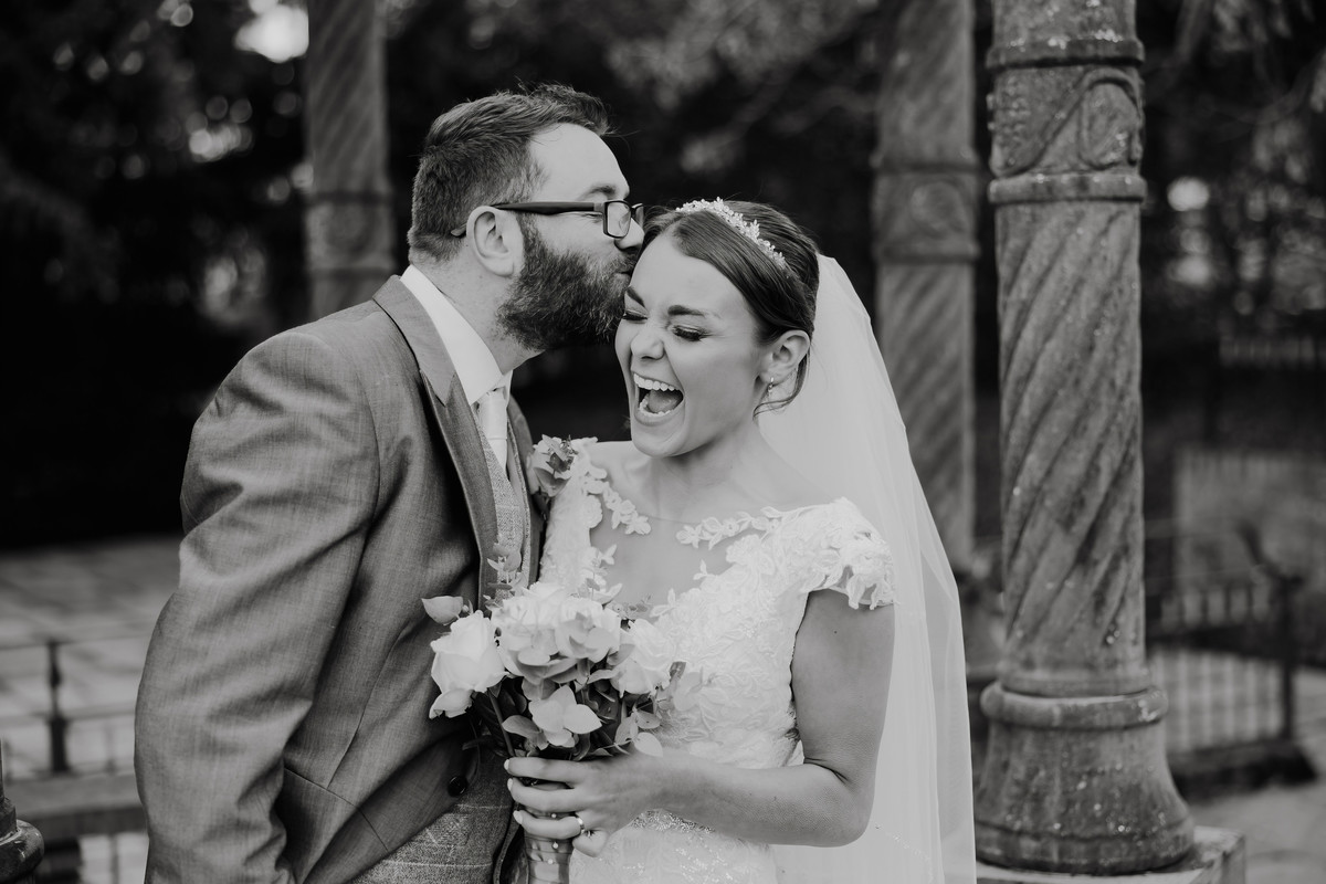 Bride laughs during couple photographs at Weston Hall