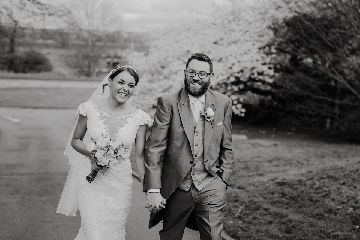 Bride and groom stroll up the drive at Weston Hall on their wedding day