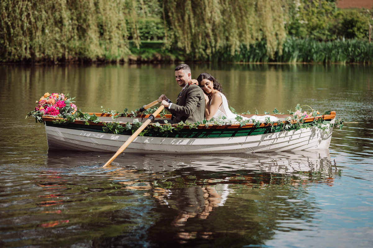 Bride and groom boating on the lake at The Moat House