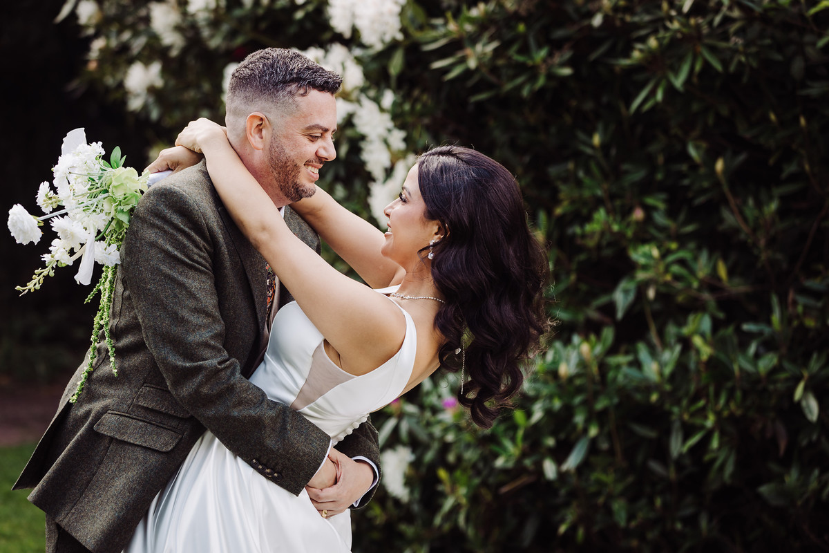 Bride and groom twirl in the gardens at The Moat House