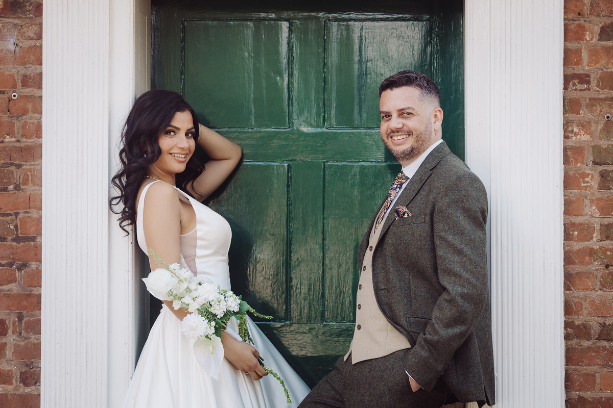 Bride and groom by the green door at The Moat House