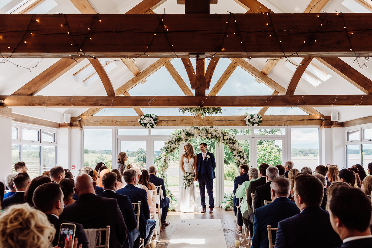 Bride and Groom stand in wedding ceremony at Blithfield Lakeside Barns