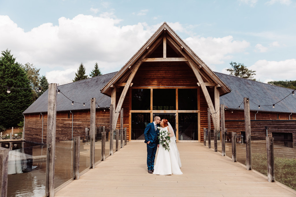 Bride and Groom kiss on the bridge at Millbarns