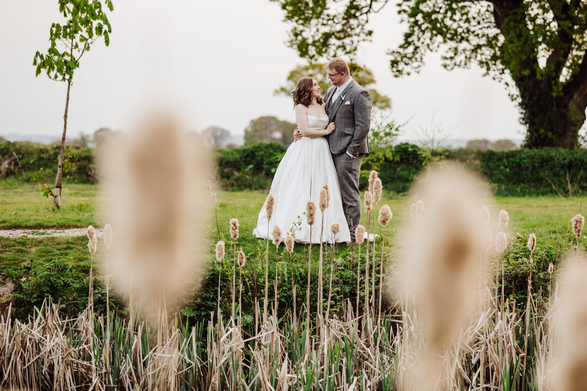 Bride and Groom by the water at Hanbury wedding Barn