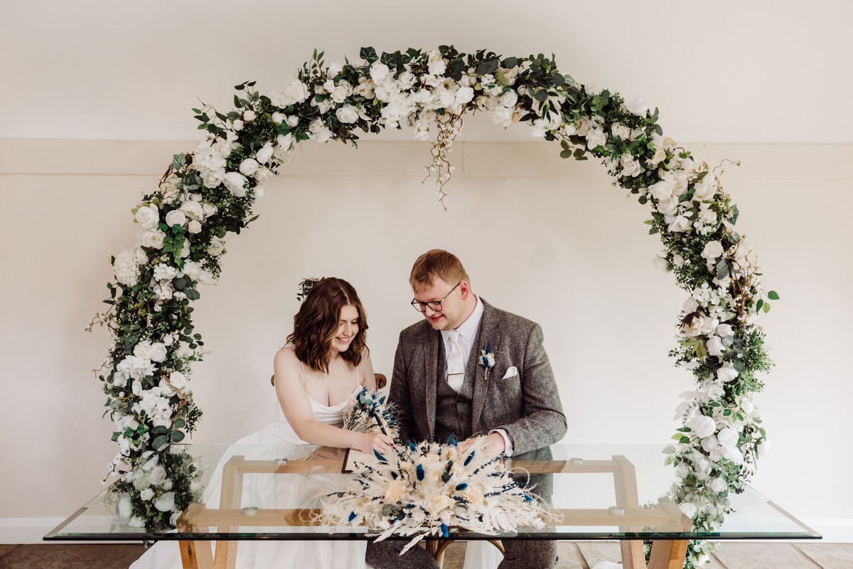 Bride and Groom sign the register at Hanbury wedding barns
