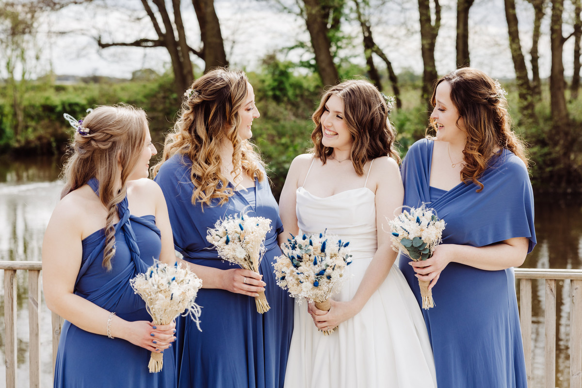 Bride and bridesmaid at the waters edge at Hanbury wedding barns