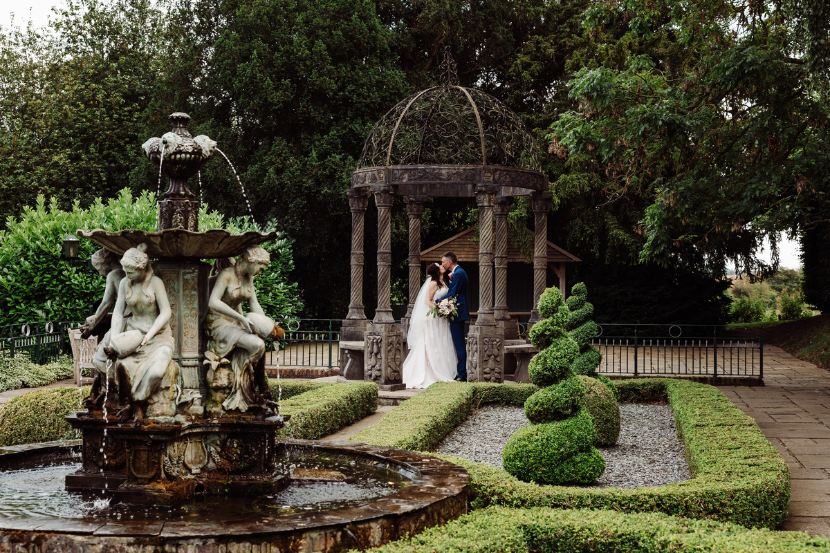 Bride and Groom kiss in the gardens at Weston Hall