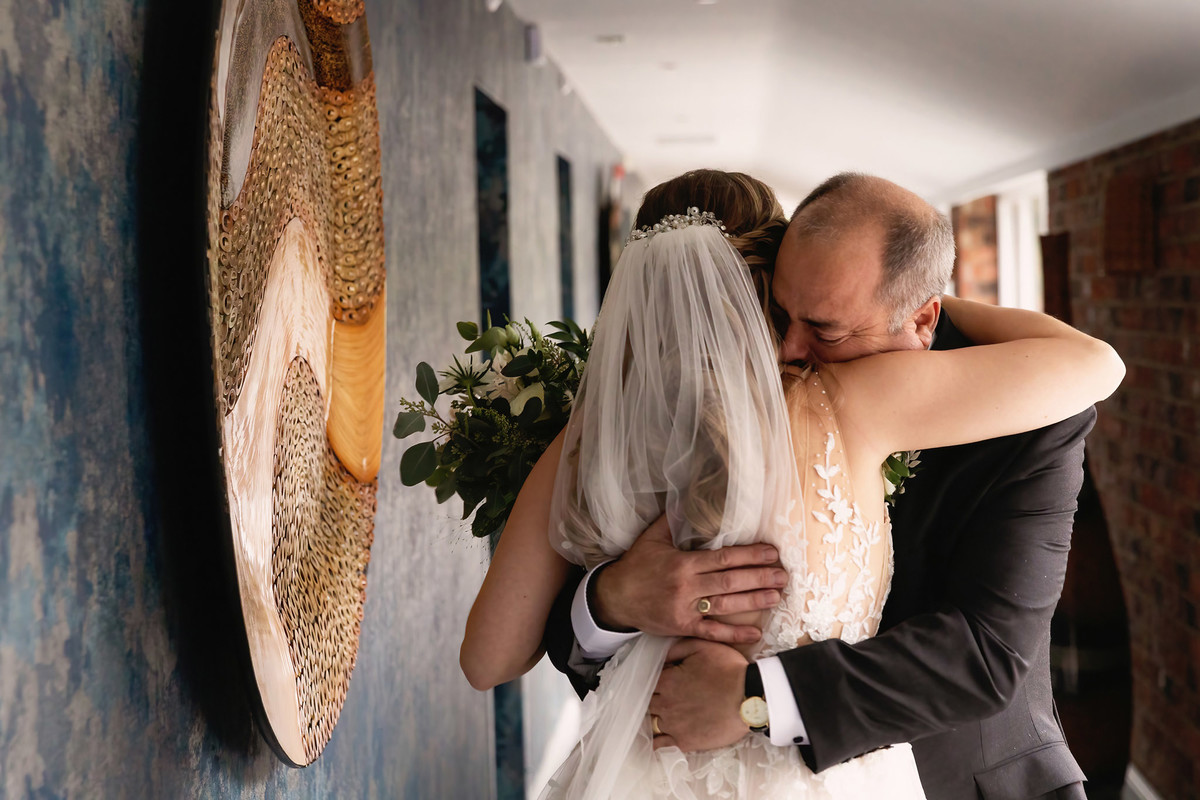 Emotional father of the bride hugs his daughter at moddershall oaks wedding