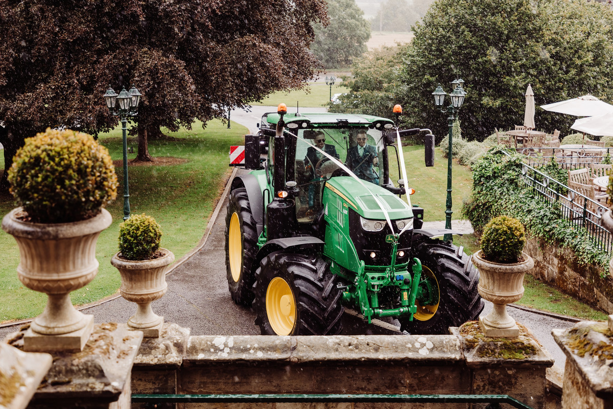 Groom arrives on a John Deere tractor at Weston Hall