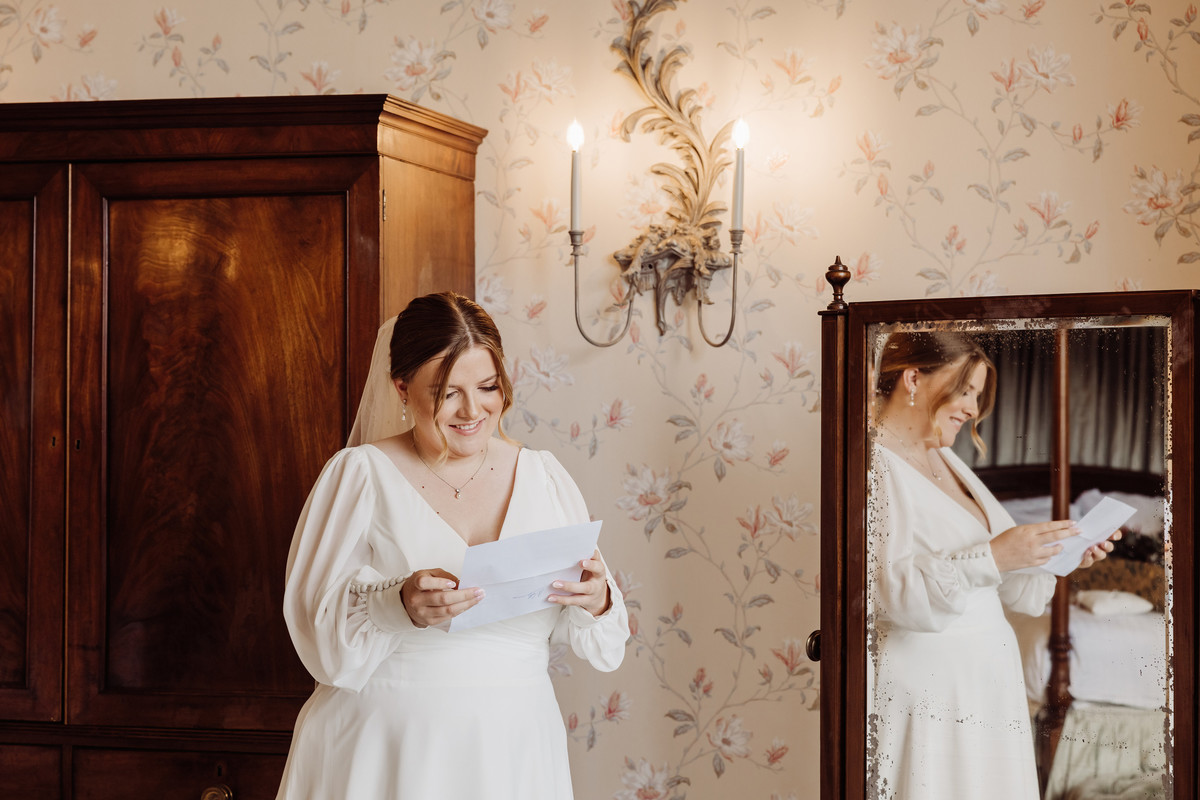 Bride reads a letter from the groom at Sandon Hall