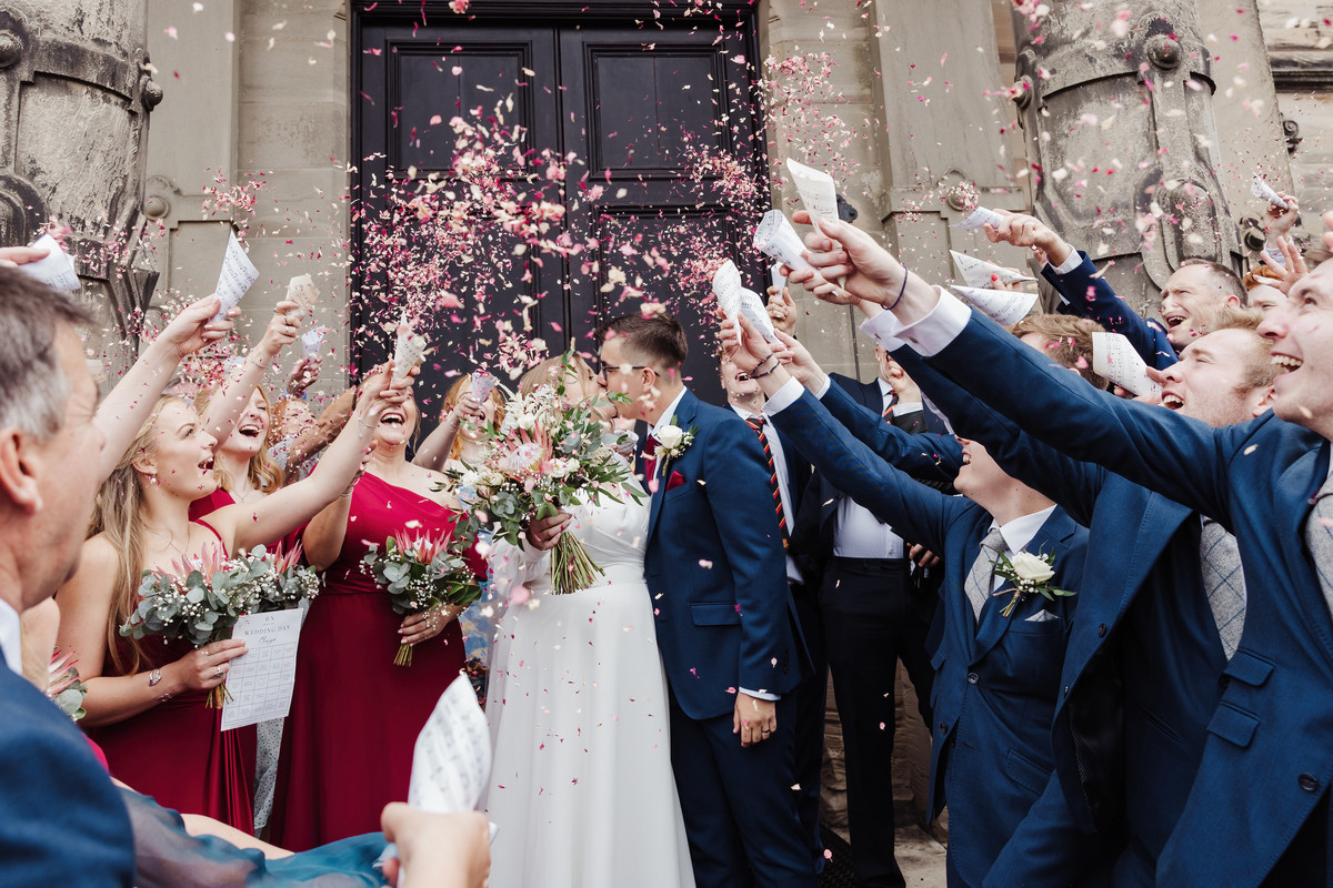 Joyful confetti photograph on the steps at Sandon Hall