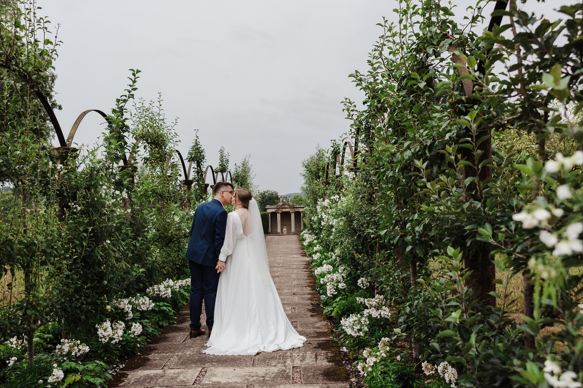 Bride and groom kiss in the rose garden at Sandon Hall