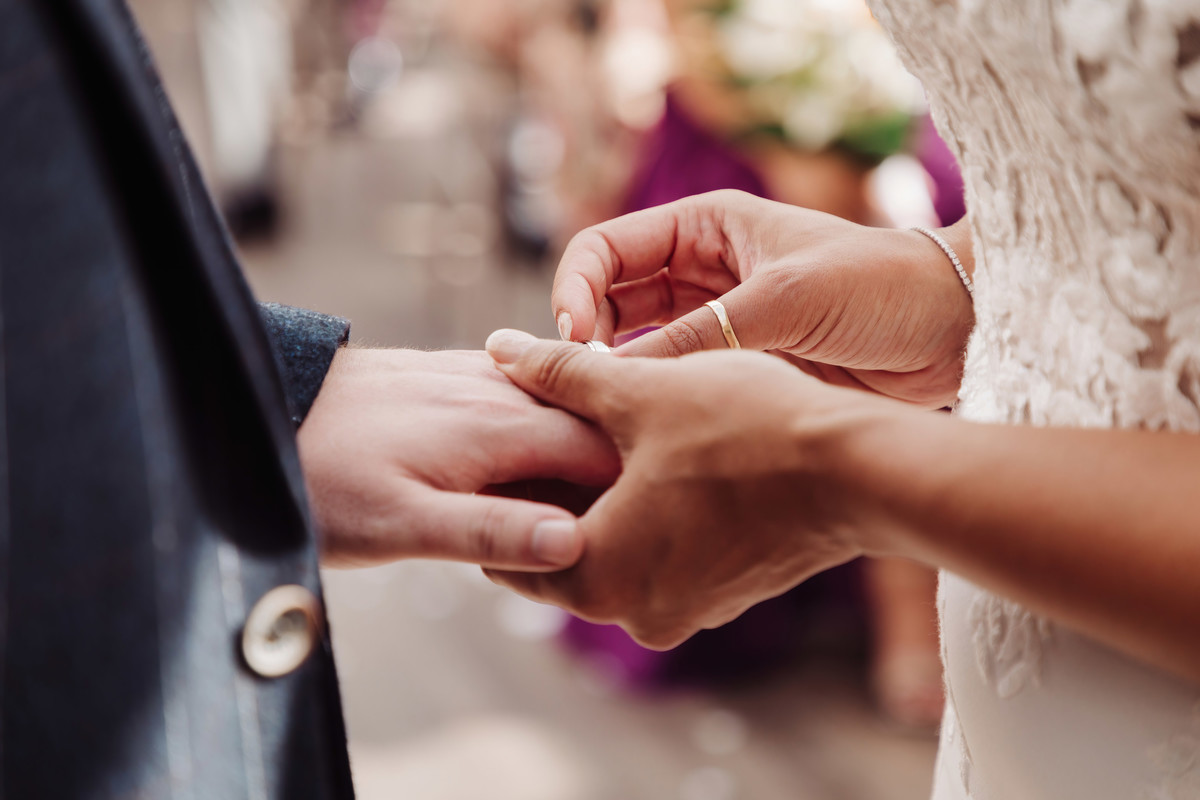 Bride and groom exchange rings during wedding ceremony at Foxtail Barns