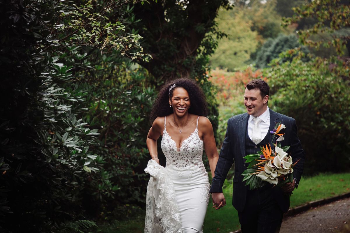 Bride laughing strolling through the grounds at her Foxtail Barns wedding