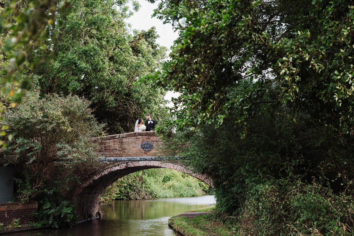 Couple laugh on the bridge over the canal at The Moat House, Staffordshire