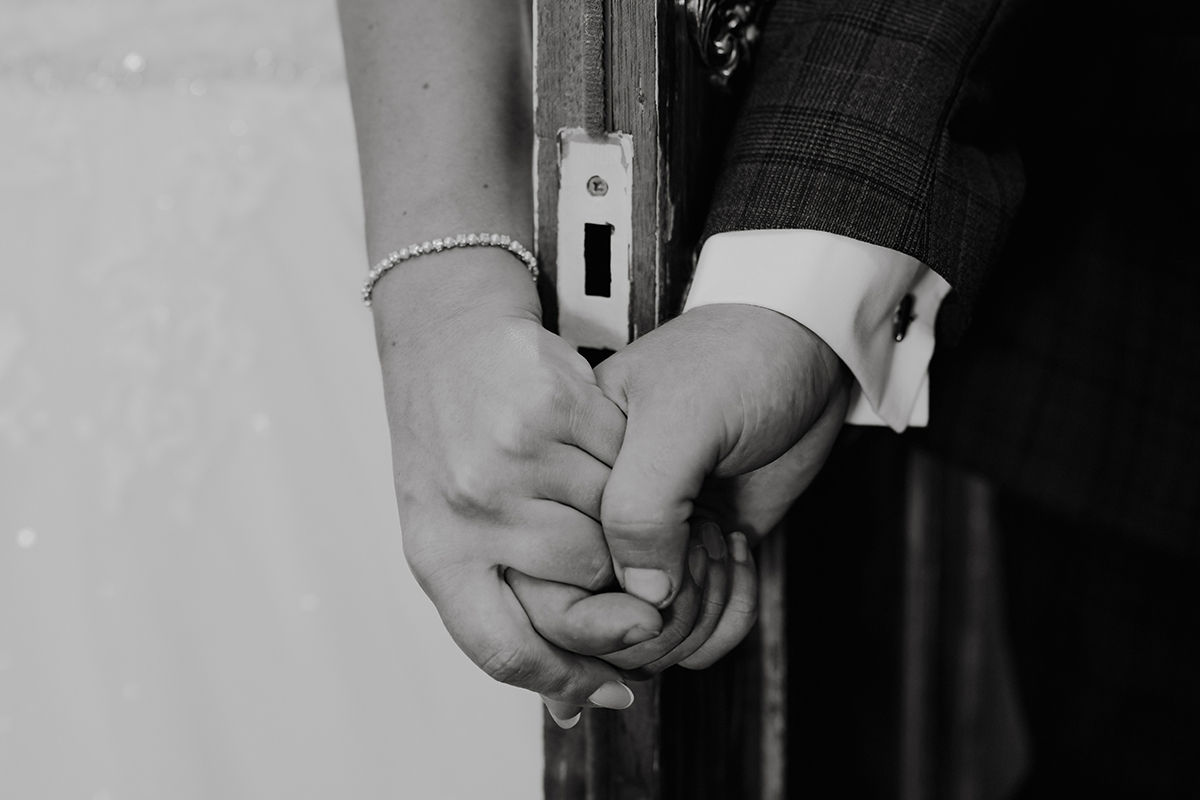 Emotional first touch before a wedding ceremony at The Hundred House Hotel