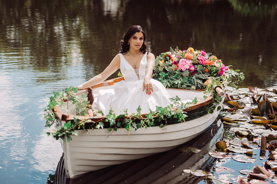 Bride in a rowing boat at The Moat House in Acton Trussell