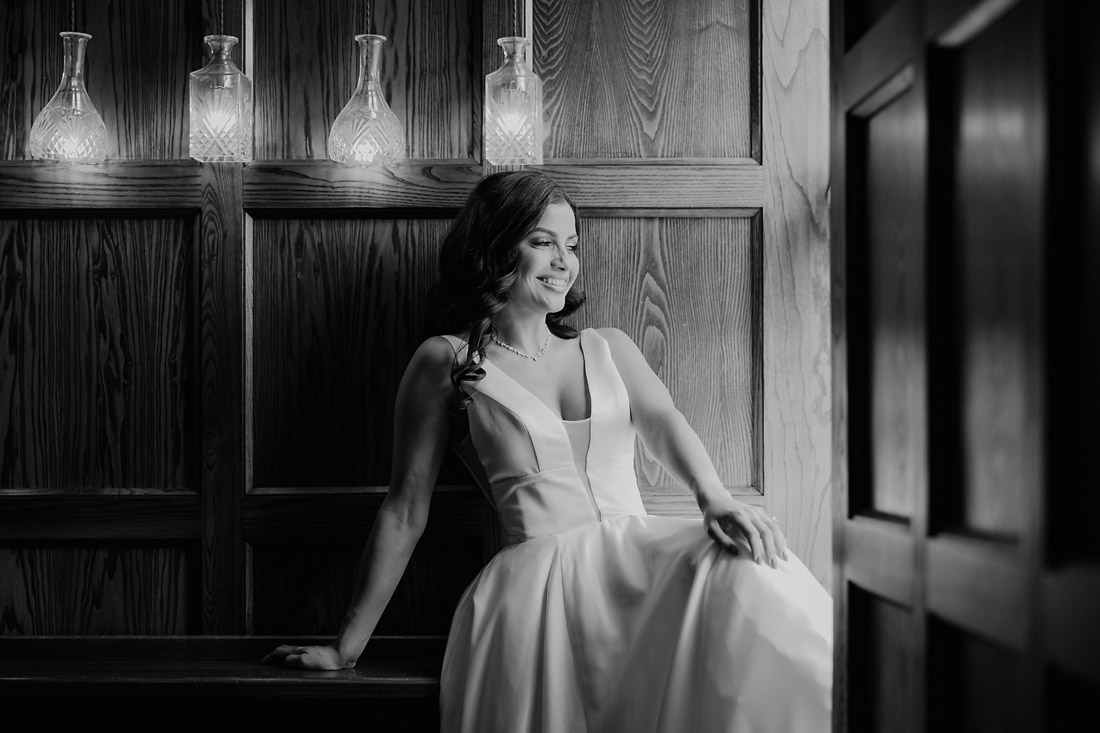 Bride in a satin wedding dress beside the window at The Moat House