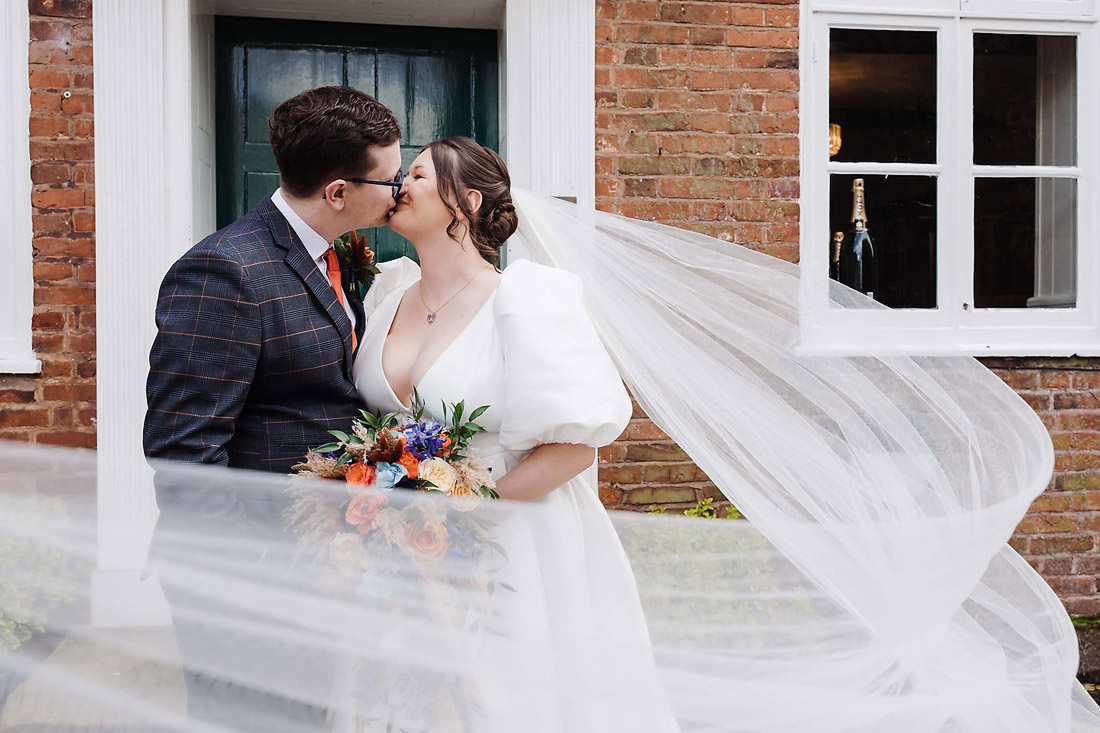 Veil shot with the bride and groom on the steps at The Moat House