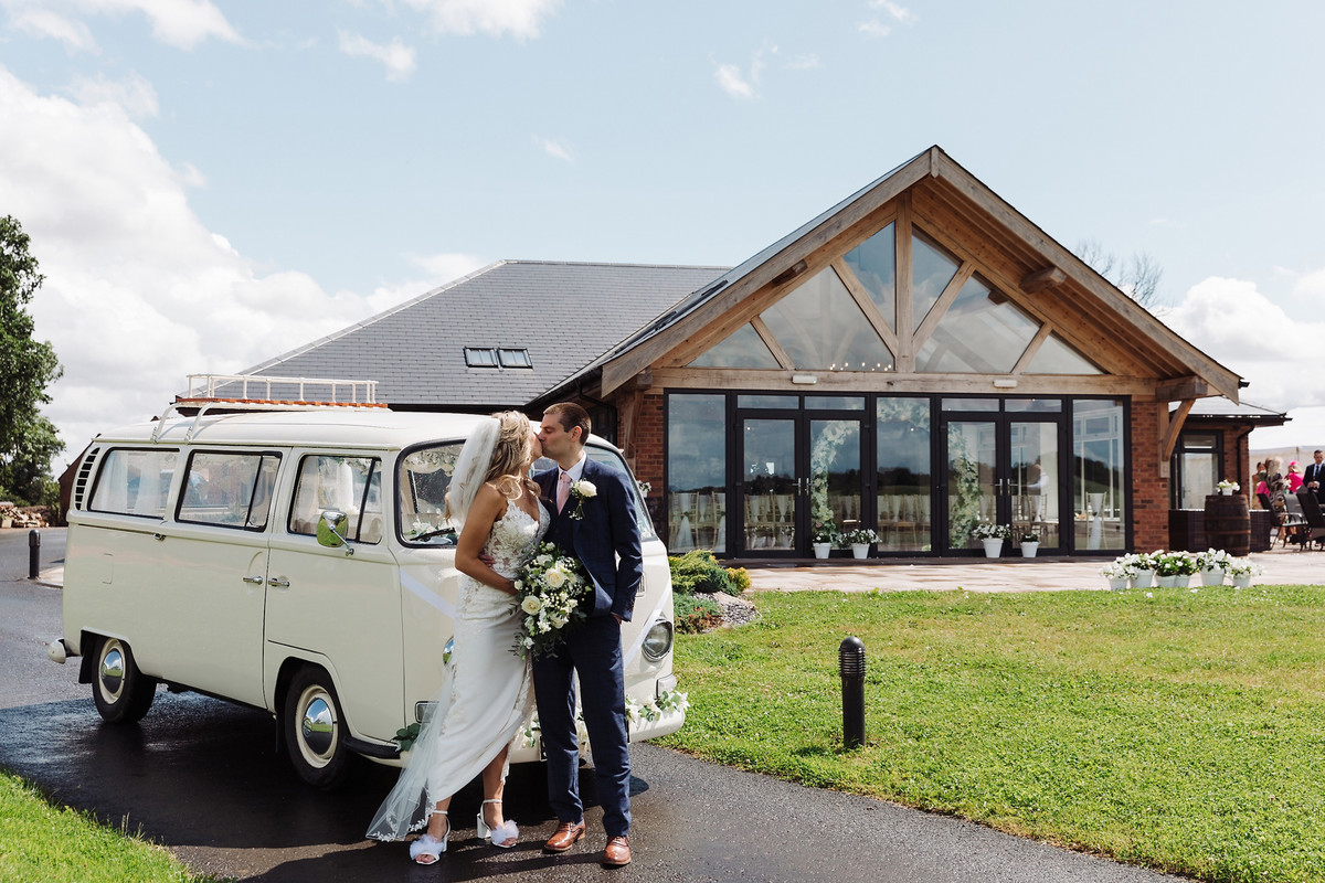 Bride and groom portraits by the camper van at Blithfield Lakeside Barns
