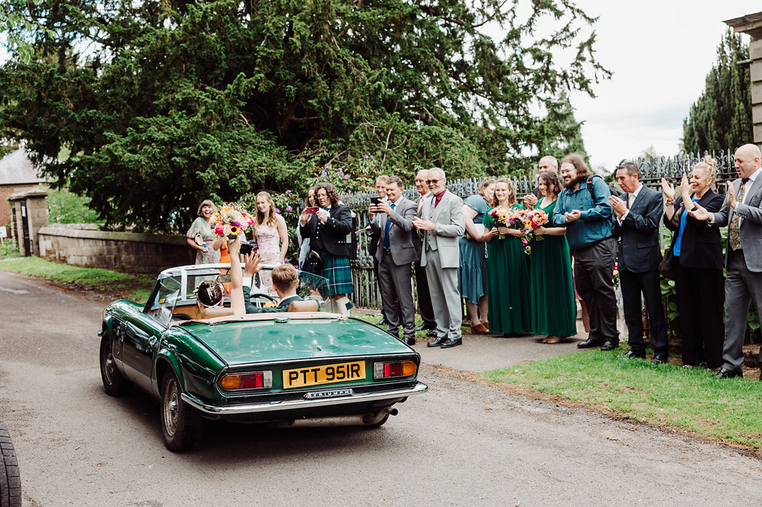 Bride and groom leave church in convertible at Ingestre